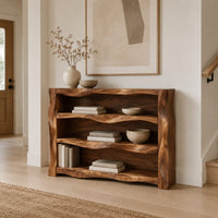 Open shelf console table with wavy sculpted sides in a Scandinavian entryway with white walls