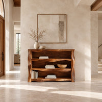 Open shelf console table with wavy sculpted sides in a bright open plan entryway