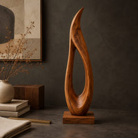 Corner detail of tall teardrop sculpture with an open center and a pointed tip beside wood, brass and linen samples