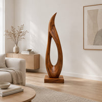 Tall teardrop sculpture with an open center and a pointed tip in a Scandinavian living room with white walls