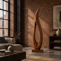 Tall teardrop sculpture with an open center and a pointed tip in an industrial loft living room with exposed brick