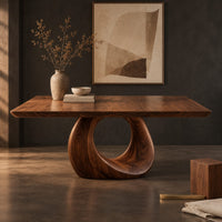 Corner detail of dining table with a slab top and an open teardrop pedestal beside wood, brass and linen samples