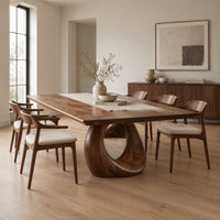Dining table with a slab top and an open teardrop pedestal in a Scandinavian dining room with white walls