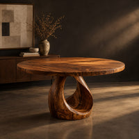 Round dining table with an open teardrop loop pedestal base, three-quarter view showing the grain