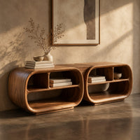 Corner detail of open tv stand with two rounded capsule frames and shelves beside wood, brass and linen samples