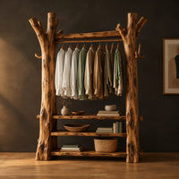 Open wardrobe with tree trunk posts, a hanging rail and three plank shelves in a dark studio against a charcoal plaster wall