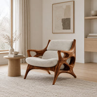 Openwork wooden lounge chair with hollowed arms and splayed legs in a Scandinavian living room with white walls