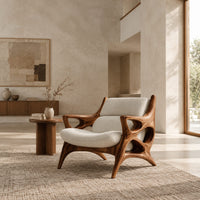 Openwork wooden lounge chair with hollowed arms and splayed legs in a bright open plan living room