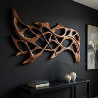 Hand carved organic openwork wooden wall sculpture, three-quarter view showing the carved depth