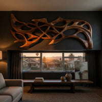 Hand carved organic openwork wooden wall sculpture above a low console in an evening living room
