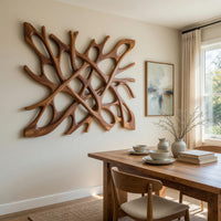 Hand carved organic openwork wooden wall sculpture beside a dining table in natural light