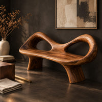 Corner detail of organic wooden bench with a raised rim, two oval cutouts and tapered legs beside wood, brass and linen samples