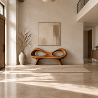 Organic wooden bench with a raised rim, two oval cutouts and tapered legs in a bright open plan entryway