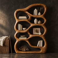 Corner detail of open bookshelf with rounded pebble shaped compartments beside wood, brass and linen samples
