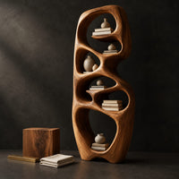 Corner detail of tall organic wooden bookshelf with uneven oval shelf pockets beside wood, brass and linen samples
