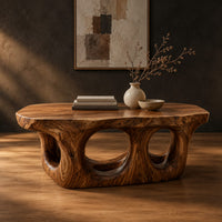 Coffee table with round porthole openings in a solid base in a dark studio against a charcoal plaster wall