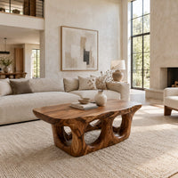 Coffee table with round porthole openings in a solid base in a bright open plan living room