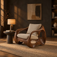 Wraparound lounge chair with open loop sides and arched base in a dark living room at golden hour