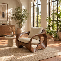 Wraparound lounge chair with open loop sides and arched base in a bright living room with arched windows and plants