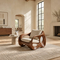 Wraparound lounge chair with open loop sides and arched base in a bright open plan living room