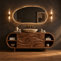 Oval vanity cabinet on tapered legs with carved wave doors and open end shelves in a dark studio against a charcoal plaster wall