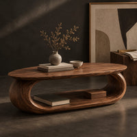 Corner detail of oval coffee table on a thick pill shaped loop base with an open middle beside wood, brass and linen samples