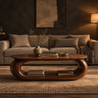 Oval coffee table on a thick pill shaped loop base with an open middle in a dark living room at golden hour