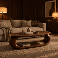 Oval coffee table on a thick pill shaped loop base with an open middle in an evening living room with walnut wall paneling