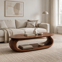 Oval coffee table on a thick pill shaped loop base with an open middle in a Scandinavian living room with white walls
