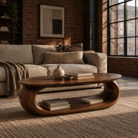 Oval coffee table on a thick pill shaped loop base with an open middle in an industrial loft living room with exposed brick