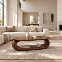 Oval coffee table on a thick pill shaped loop base with an open middle in a bright open plan living room