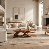 Oval coffee table on a twisting ribbon base with an open loop in a bright open plan living room