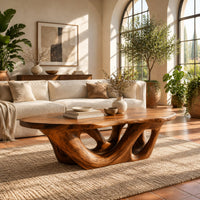 Oval coffee table on an interlaced base with open loops in a bright living room with arched windows and plants