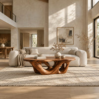 Oval coffee table on an interlaced base with open loops in a bright open plan living room