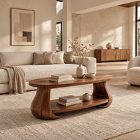 Oval coffee table with swelling tulip shaped legs and a lower shelf in a bright open plan living room