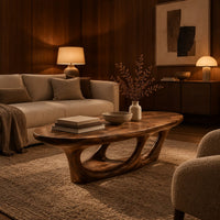 Oval coffee table with a sculpted open loop base in an evening living room with walnut wall paneling