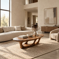 Oval coffee table with a sculpted open loop base in a bright open plan living room