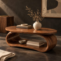 Corner detail of oval coffee table on a bent loop base with a low shelf inside beside wood, brass and linen samples