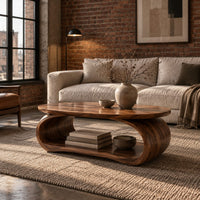 Oval coffee table on a bent loop base with a low shelf inside in an industrial loft living room with exposed brick