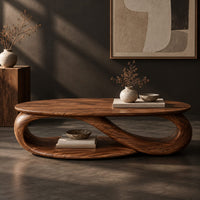 Corner detail of oval coffee table with an infinity loop base and lower shelf beside wood, brass and linen samples