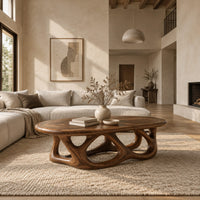 Oval coffee table on a base of interlocking open arches in a bright open plan living room