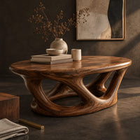 Corner detail of oval coffee table on interlocking looped wooden legs with a thick top beside wood, brass and linen samples