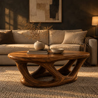 Oval coffee table on interlocking looped wooden legs with a thick top in a dark living room at golden hour