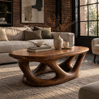 Oval coffee table on interlocking looped wooden legs with a thick top in an industrial loft living room with exposed brick