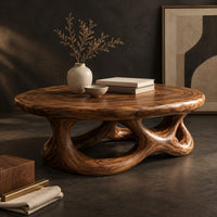 Corner detail of oval coffee table with a knotted openwork wooden base beside wood, brass and linen samples