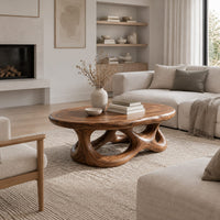 Oval coffee table with a knotted openwork wooden base in a Scandinavian living room with white walls