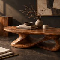 Corner detail of oval coffee table on a looping ribbon base with open gaps beside wood, brass and linen samples