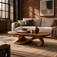 Oval coffee table on a looping ribbon base with open gaps in an industrial loft living room with exposed brick