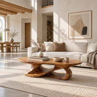 Oval coffee table on a looping ribbon base with open gaps in a bright open plan living room