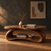 Oval wood coffee table on a looping ribbon base with an open lower shelf in a dark studio against a charcoal plaster wall